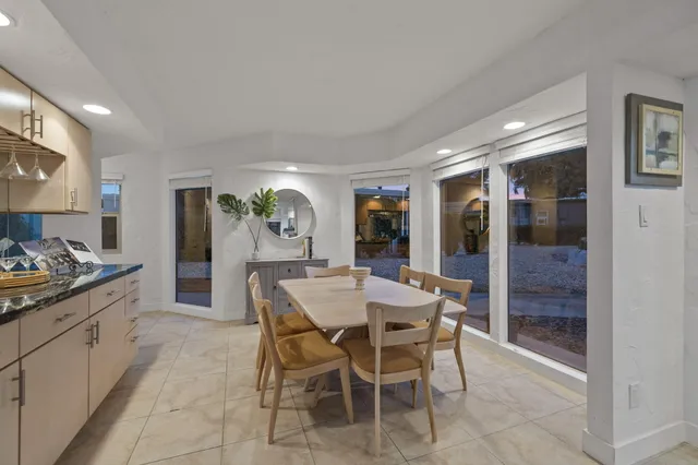 a kitchen with stainless steel appliances kitchen island granite countertop a table and chairs in it