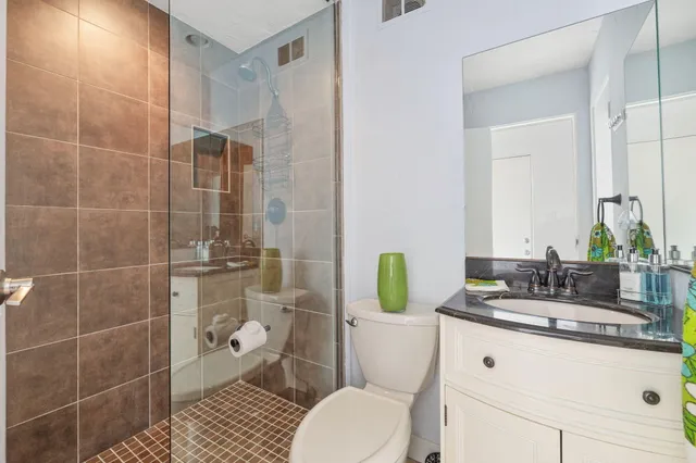 a bathroom with a granite countertop toilet sink and mirror