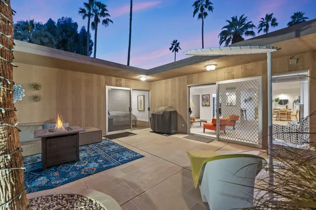 a living room with furniture a lamp and a potted plant