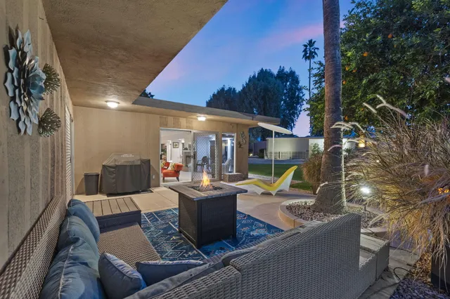a view of a patio with couches and table and chairs with wooden fence