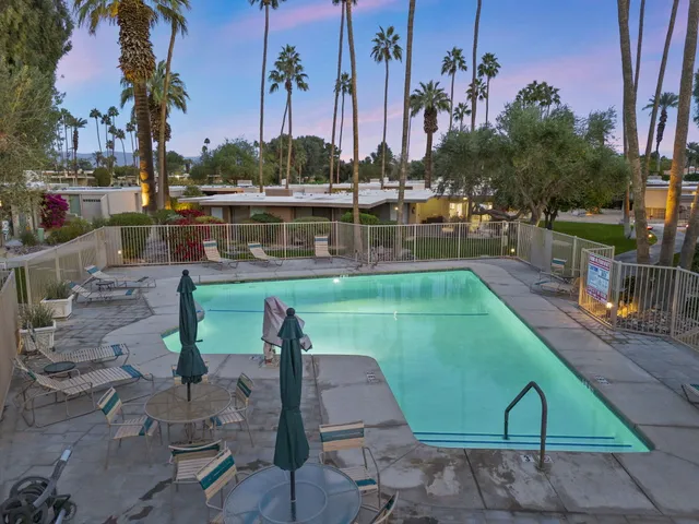 a view of a swimming pool with a patio and a yard