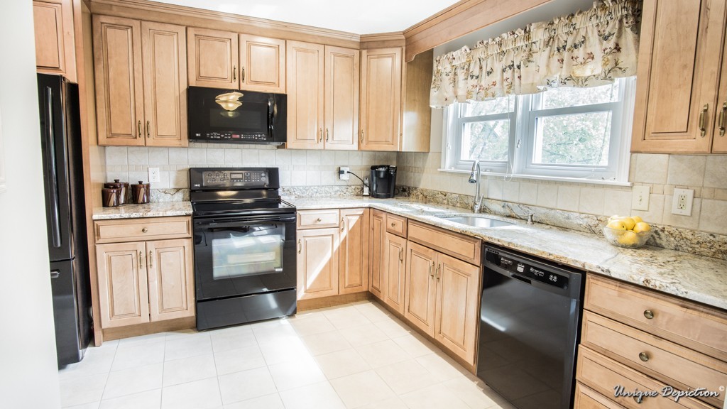 10 Evergreen Way, Unit 10 Peabody, MA 01960 - Photo 4 of 24 a kitchen with granite countertop a sink a window stainless steel appliances and cabinets