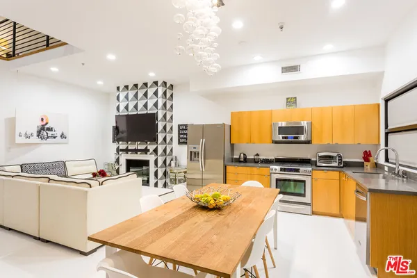 a kitchen with stainless steel appliances wooden floor and refrigerator