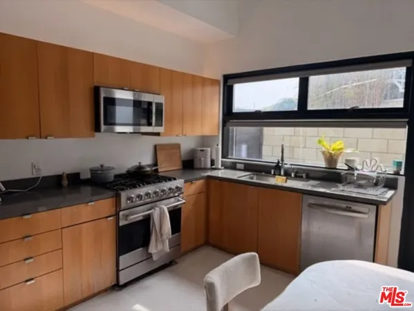 a kitchen with stainless steel appliances a stove sink and microwave