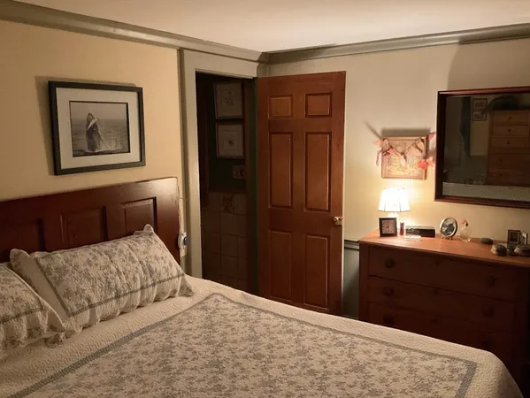 a bedroom with a bed and a flat tv screen on dresser