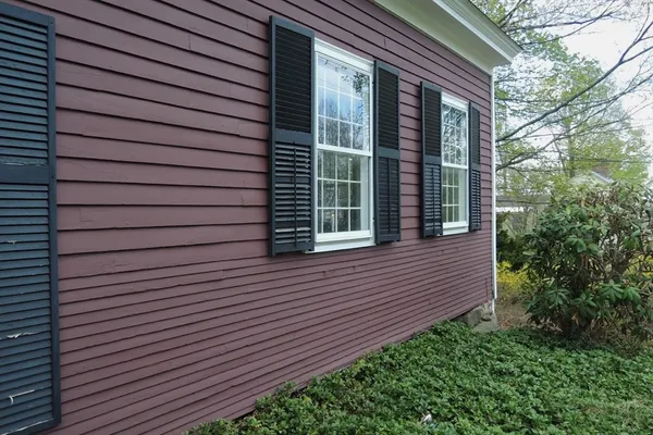 a view of brick house with a large window and flower plants