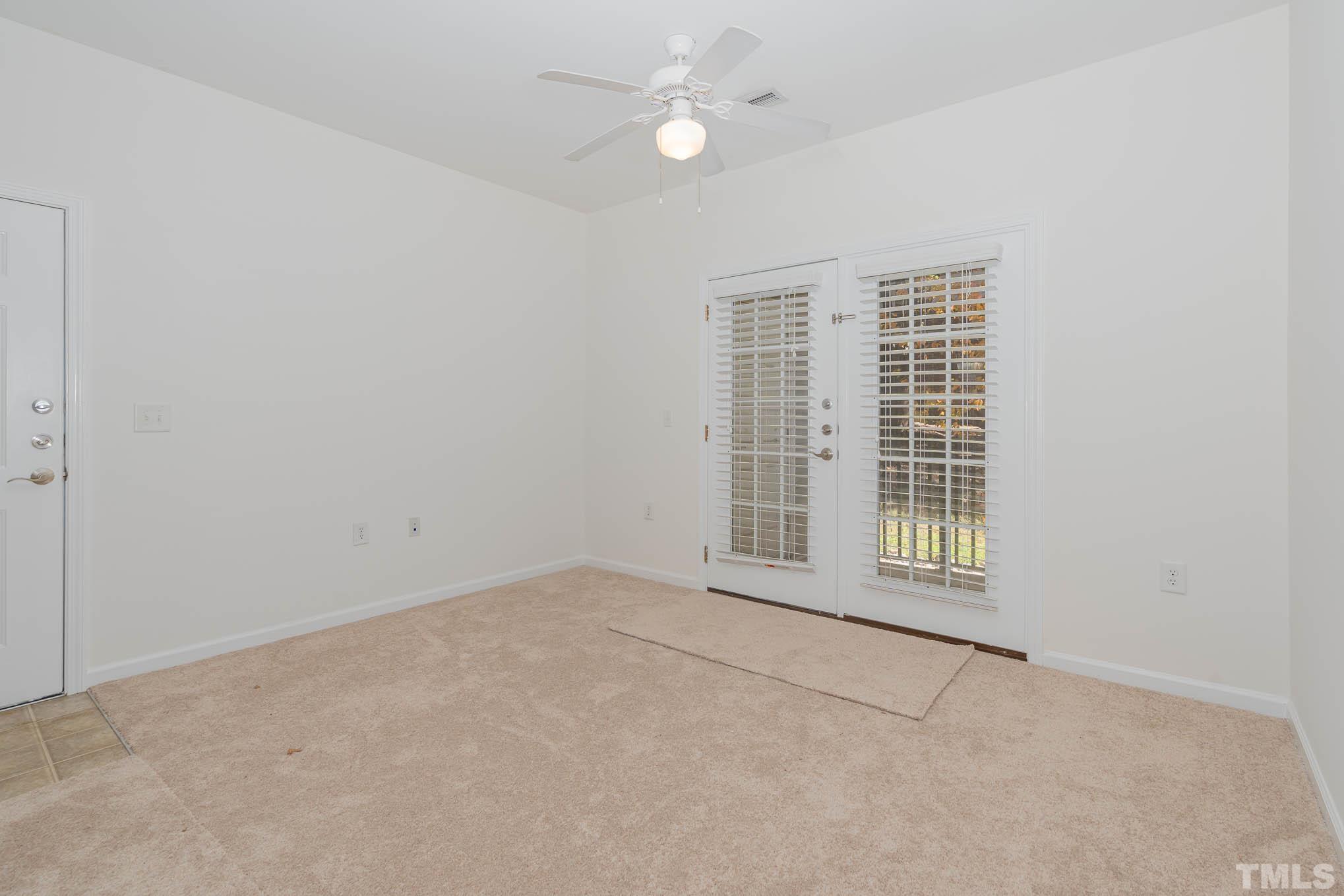 2631 Oldgate Drive, Unit 103 Raleigh, NC 27604 - Photo 3 of 15 an empty room with chandelier fan and windows
