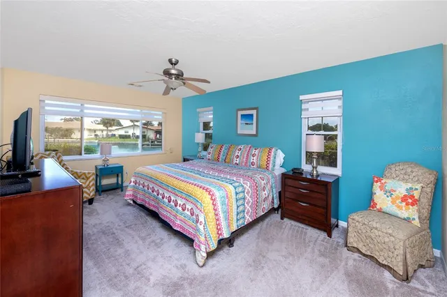 a bedroom with a bed and large windows