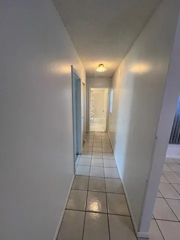 a view of hallway with a window and a kitchen