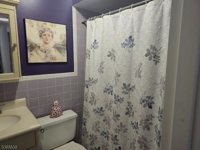a bathroom with a toilet and a shower curtain