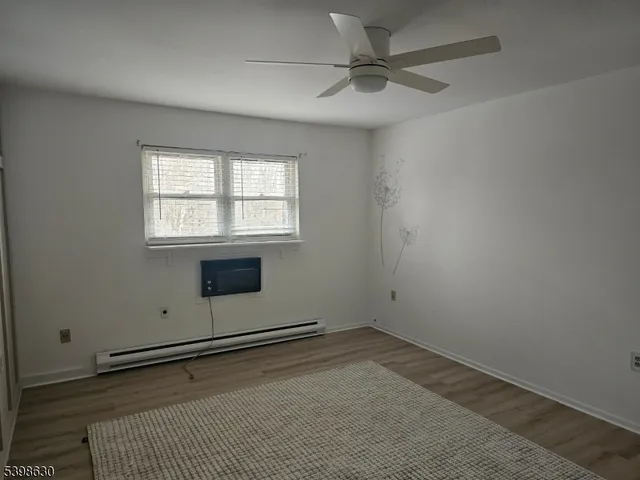 an empty room with a window and a ceiling fan