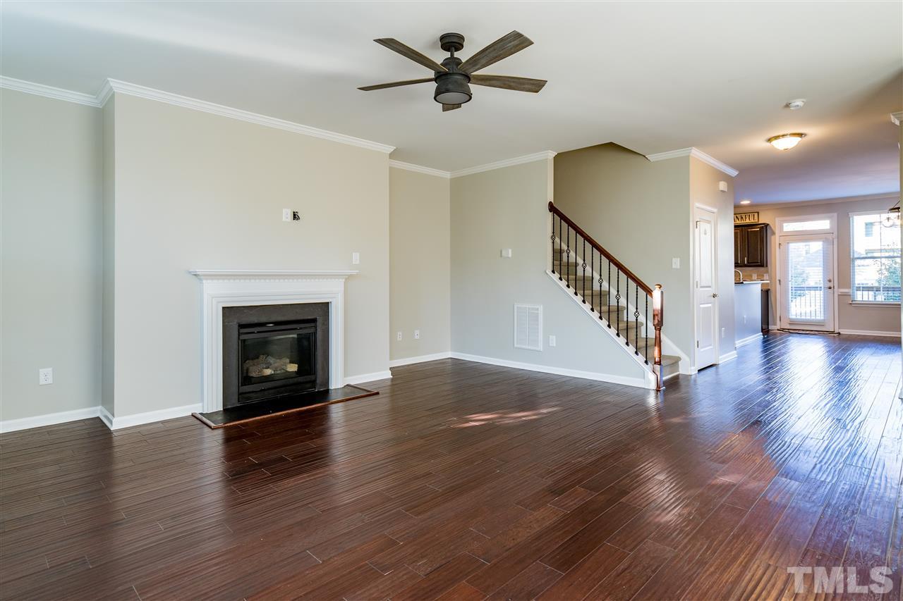 1521 Rodessa Run Raleigh, NC 27607 - Photo 11 of 29 Main level living room with fireplace, hardwoods, 9' ceilings, ceiling fan and windows to overlook the tree lined street.