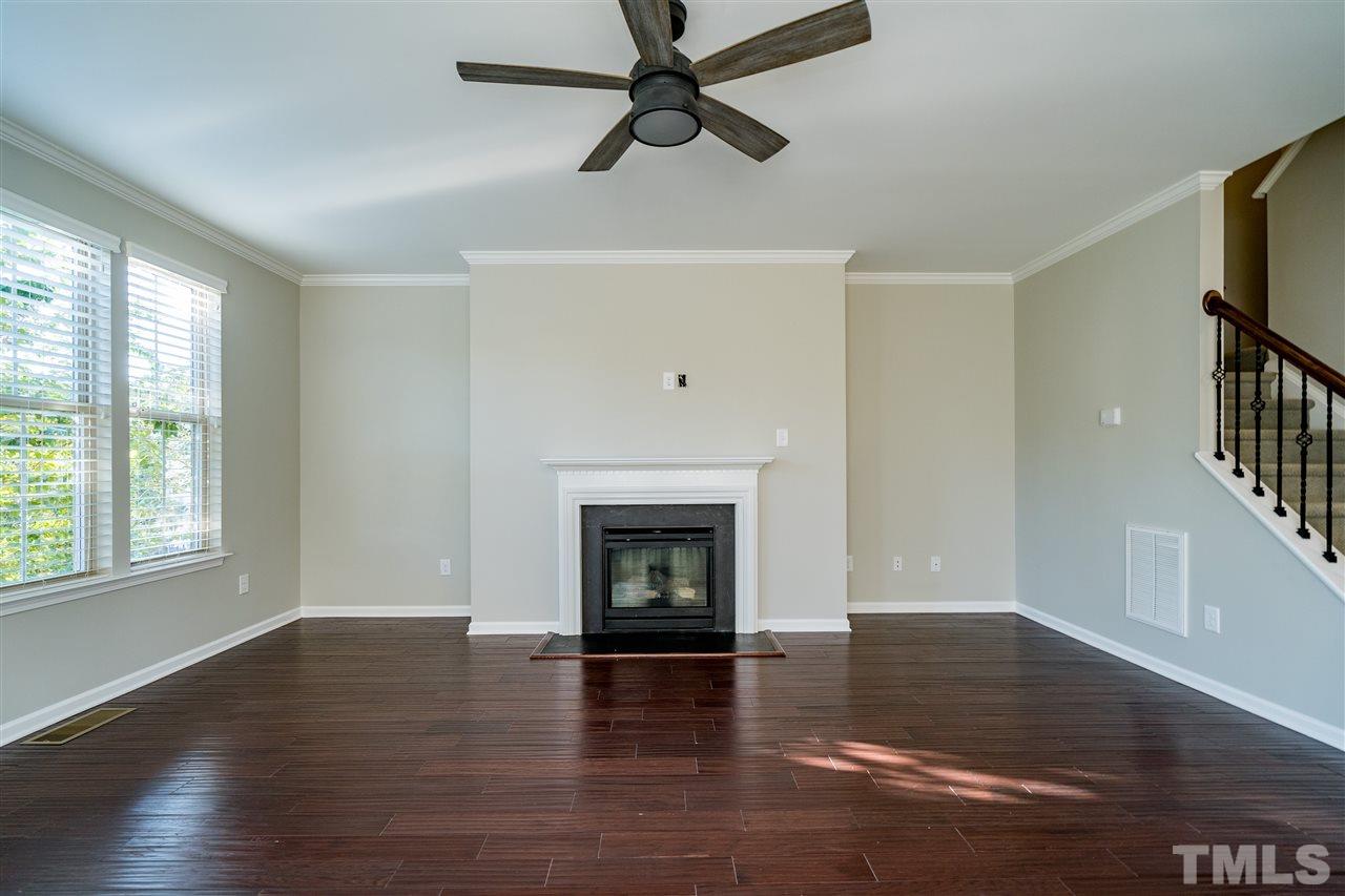 1521 Rodessa Run Raleigh, NC 27607 - Photo 10 of 29 Main level living room with fireplace, hardwoods, 9' ceilings, ceiling fan and windows to overlook the tree lined street.