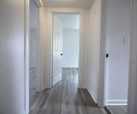 a view of a hallway with wooden floor