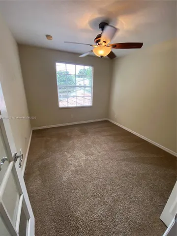a view of a livingroom with a ceiling fan and window