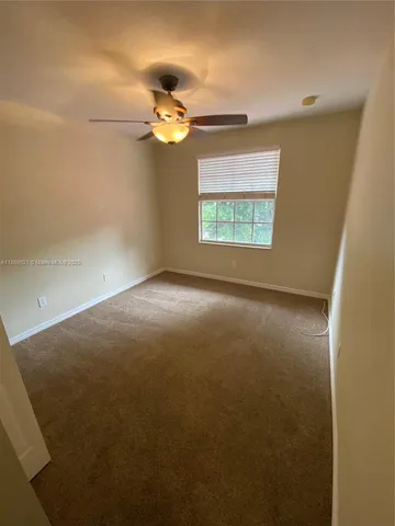 an empty room with a fan and a fan