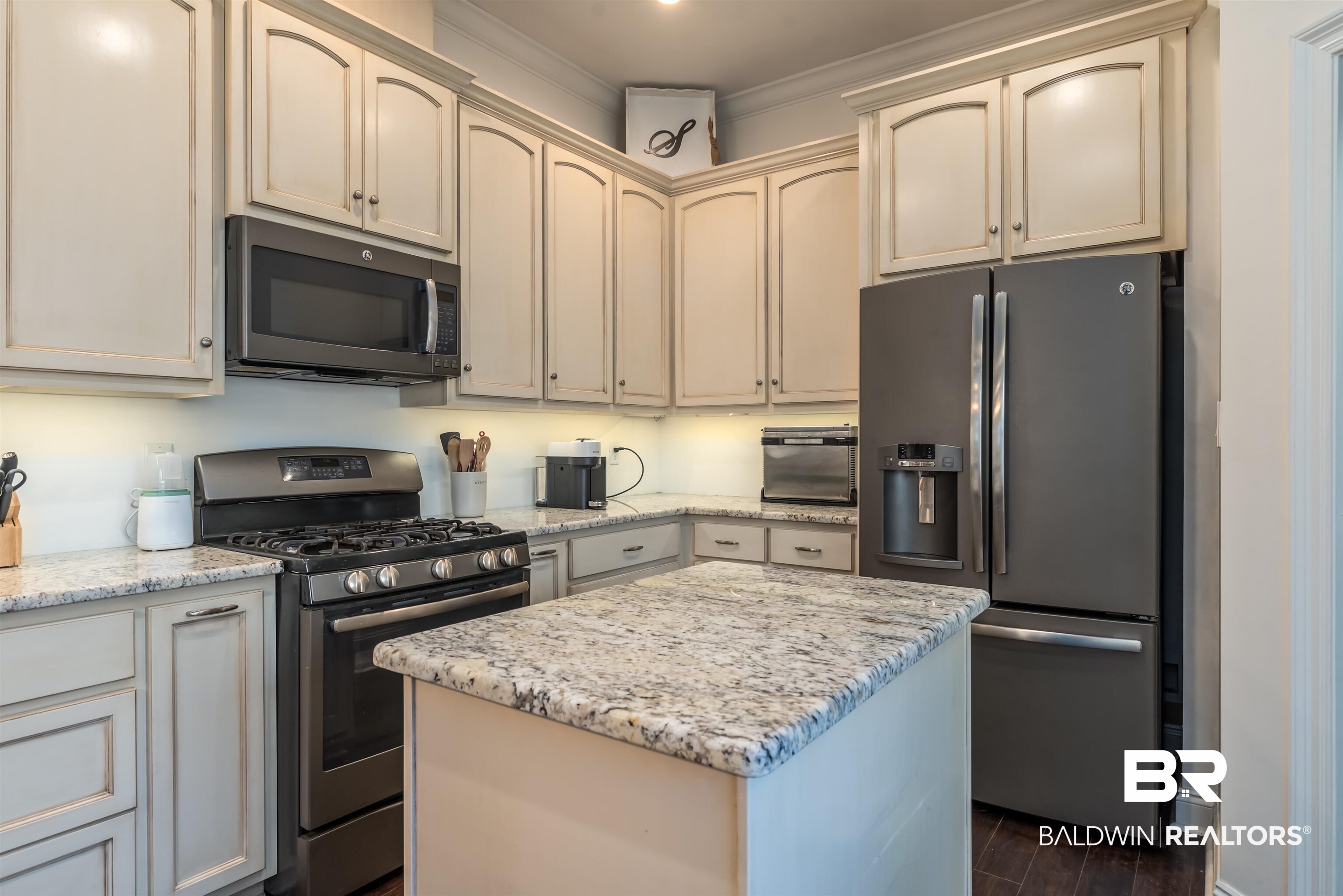965 Henckley Avenue Mobile, AL 36609 - Photo 8 of 30 Kitchen featuring stainless steel appliances, dark wood-type flooring, cream cabinetry, and a center island