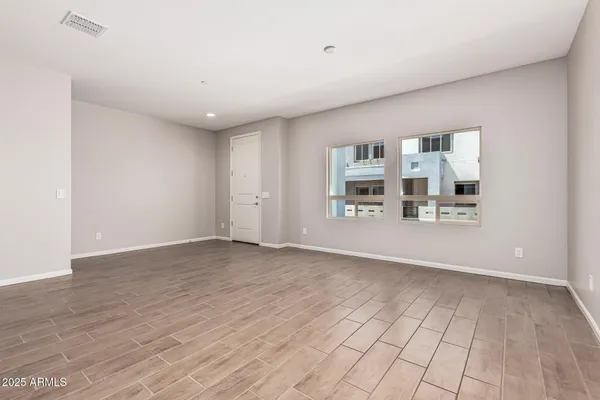 a view of a livingroom with wooden floor and a kitchen space