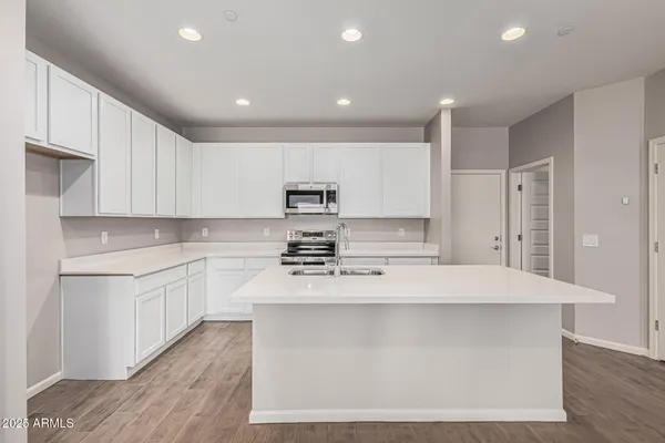 a kitchen with kitchen island sink stove and cabinets