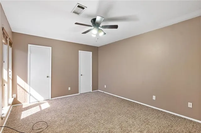 an empty room with closet and windows