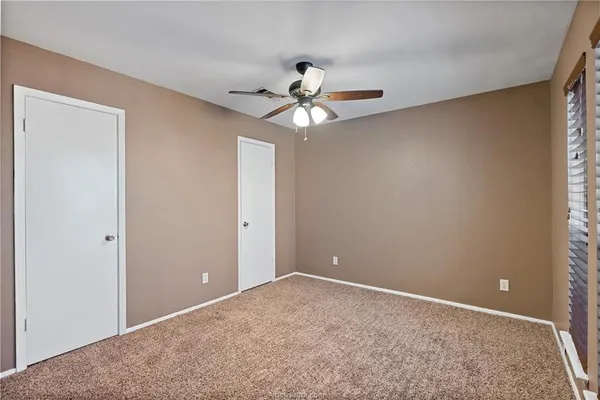 a view of a room with a ceiling fan and a window