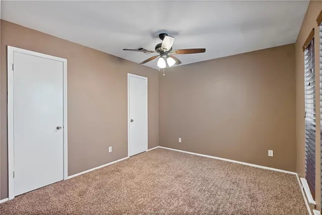 a view of a room with a ceiling fan and a window