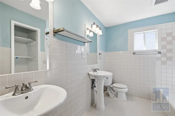 a white toilet sitting next to a bathroom sink