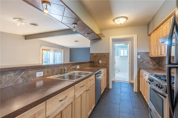 a large kitchen with a sink and dishwasher with a large window