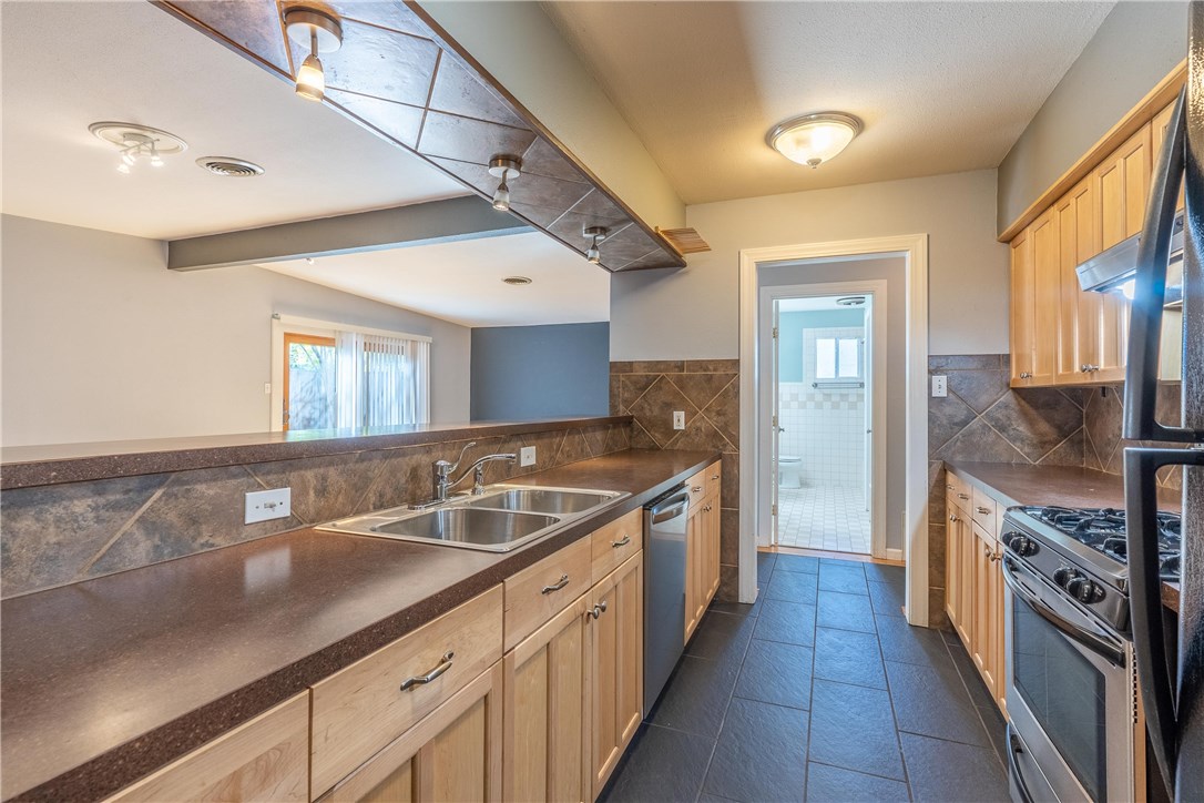 2416 South 5th Street, Unit B Austin, TX 78704 - Photo 3 of 28 a large kitchen with a sink and dishwasher with a large window