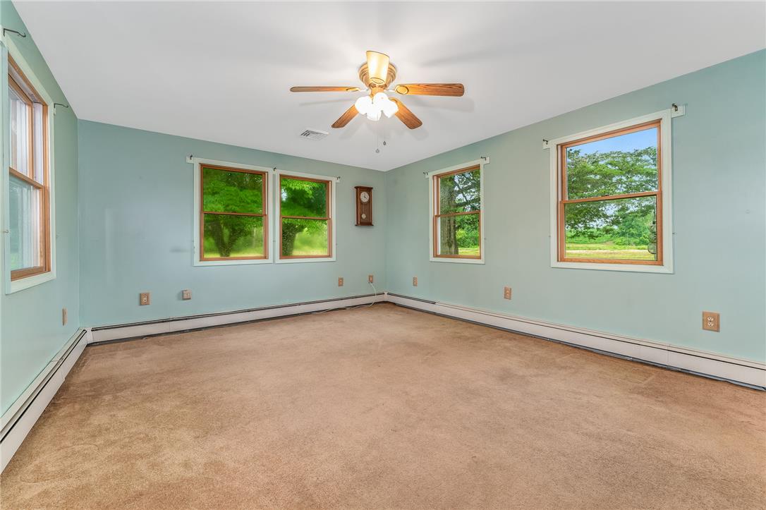 4831 Steuben Road Nazareth, PA 18064 - Photo 9 of 34 A well-lit bedroom features multiple windows showcasing verdant outdoor views and a practical ceiling fan.