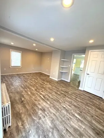 an empty room with a fireplace and wooden floor
