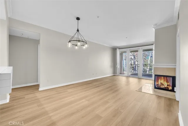 a view of an empty room with wooden floor fireplace and a window
