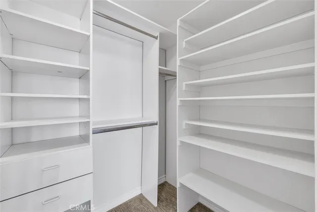 a view of walk in closet with empty racks