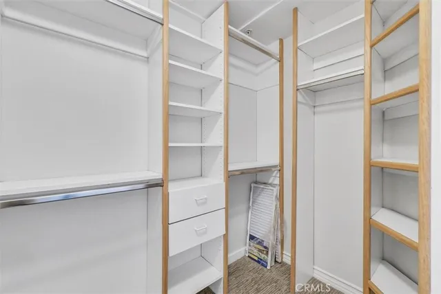 a view of walk in closet with empty racks