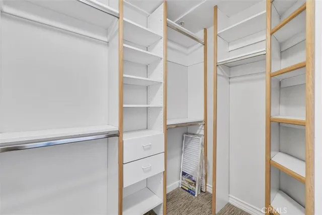 a view of walk in closet with empty racks