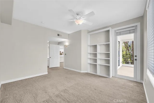 a view of an empty room with a ceiling fan