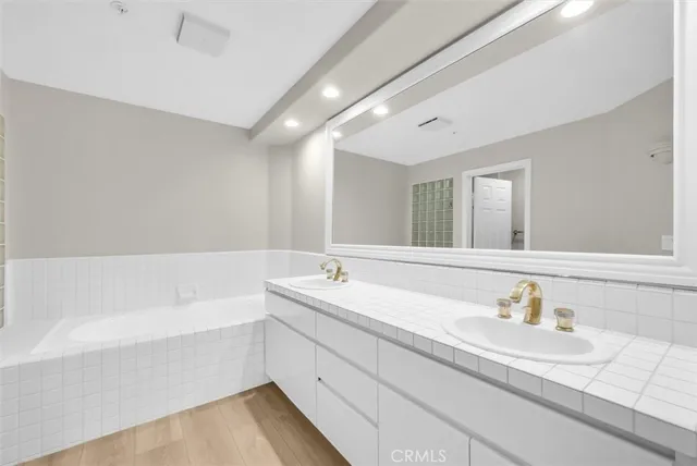 a bathroom with a tub sink and mirror