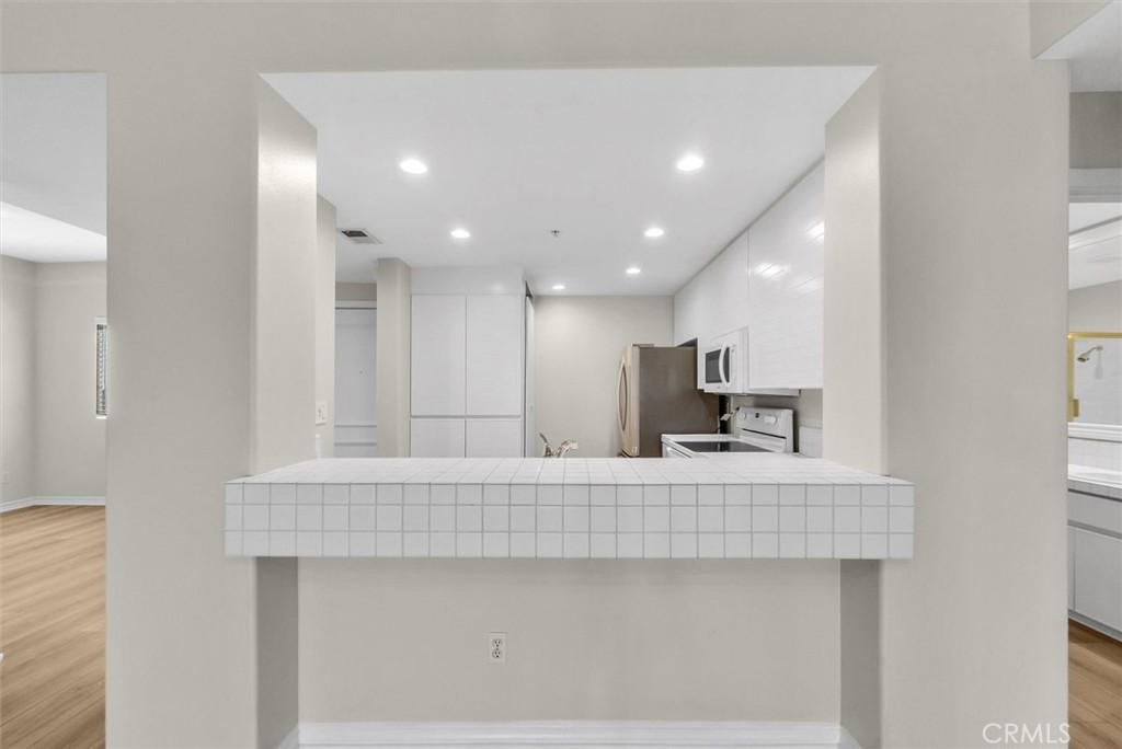 2243 Martin Irvine, CA 92612 - Photo 8 of 36 a large white kitchen with kitchen island a sink a stove and a refrigerator