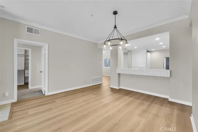 a view of a big room with wooden floor and windows