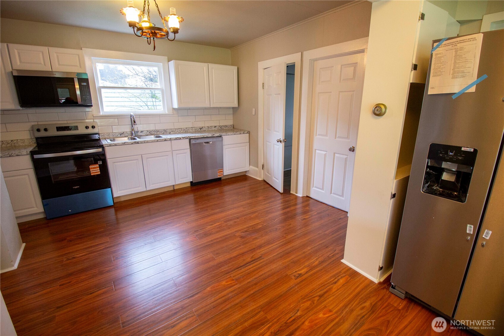 412 5th Street Hoquiam, WA 98550 - Photo 2 of 17 a kitchen with granite countertop a refrigerator a stove top oven a sink and wooden floor