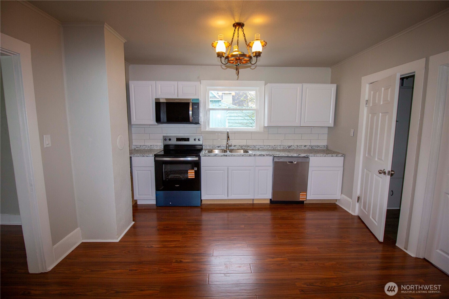 412 5th Street Hoquiam, WA 98550 - Photo 3 of 17 a kitchen with stainless steel appliances granite countertop a stove top oven a sink and dishwasher with wooden floor