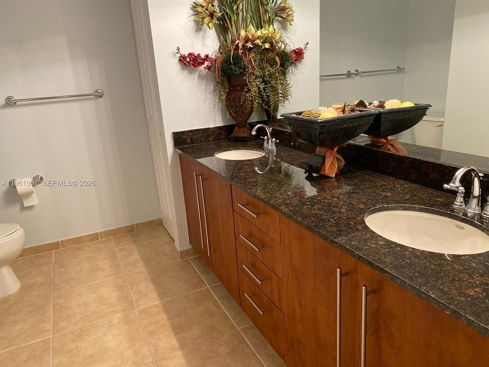 7350 Southwest 89th Street, Unit 2104S Miami, FL 33156 - Photo 17 of 30 a bathroom with a granite countertop sink and a mirror