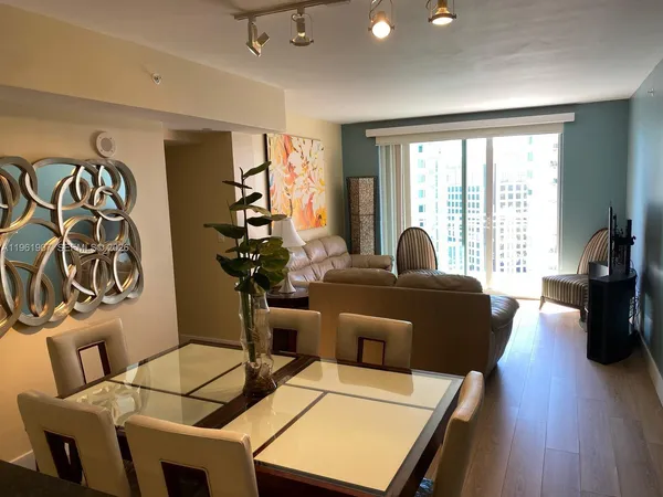 a living room with furniture and two large window