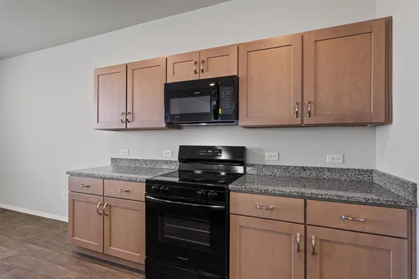 a kitchen with granite countertop cabinets stainless steel appliances and a wooden floor