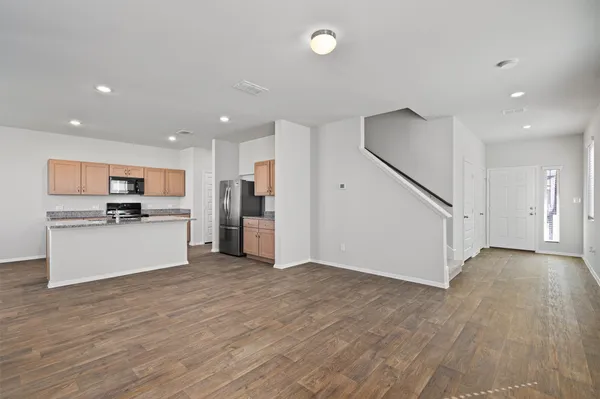 a view of kitchen with stainless steel appliances kitchen island wooden floor and window