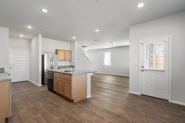 a kitchen with stainless steel appliances kitchen island granite countertop a stove a sink and a refrigerator