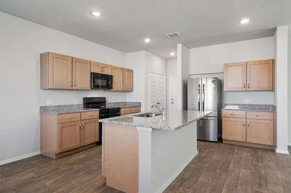 a kitchen with a refrigerator a stove top oven a sink dishwasher and wooden floor