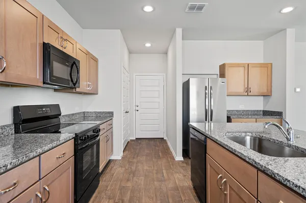 a kitchen with stainless steel appliances granite countertop a sink stove and refrigerator