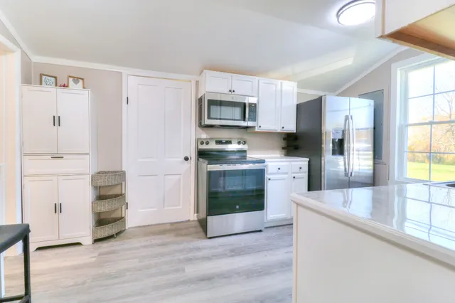 a kitchen with granite countertop a refrigerator and a stove top oven