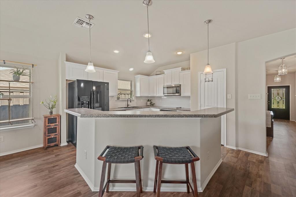 409 Harding Lane Lavon, TX 75166 - Photo 22 of 34 Modern kitchen featuring white cabinetry, grey countertops, stainless steel appliances, and pendant lighting